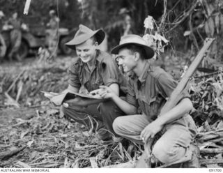 CAPE WOM, WEWAK AREA, NEW GUINEA. 1945-05-06. SERGEANT A.K. ERBY (1), WITH PRIVATE M. LEMISH (2), STUDYING A MAP OUTSIDE HEADQUARTERS MILITARY HISTORY SECTION