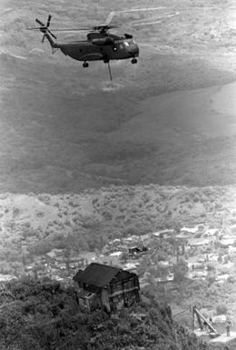 A Marine Heavy Helicopter Squadron 463 (HMH-463) CH-53D Sea Stallion helicopter transports a winch to the Coast Guard Omega Station, Haiku Valley