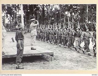 TOROKINA, BOUGAINVILLE, 1945-05-11. LT-GEN V.A.H. STURDEE, GOC FIRST ARMY (1), TAKING THE SALUTE DURING THE MARCH PAST BY TROOPS OF 25 INFANTRY BATTALION (A.I.F.)