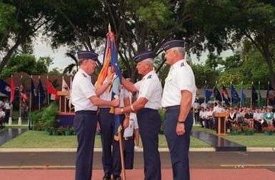 GEN. Thomas S. Mormon, Jr., USAF Vice CHIEF of STAFF, receives the flag from outgoing Pacific Air Force Commander GEN. Robert L. Rutherford during the Pacific Air Force Change of Command ceremony where GEN. Rutherford relinquishes command to GEN. John G. Lorber