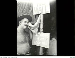 NADZAB, NEW GUINEA. C. 1944-02. "DRY YOUR EYES" IS THE RAAF WAY OF SAYING "STOP COMPLAINING". A BARE-CHESTED SERGEANT E. R. JOLLEY OF STONES CORNER, QLD, USES A "CRYING TOWEL" HUNG OUTSIDE AN AIR ..