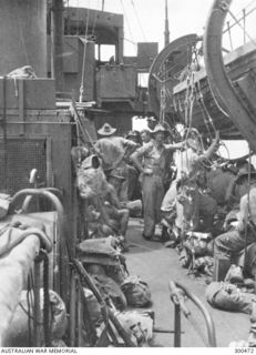 1942-12. MEMBERS OF THE 2/9 INFANTRY BATTALION, AIF, ON BOARD THE CORVETTE HMAS BROOME EN-ROUTE FROM MILNE BAY TO ORO BAY TO TAKE PART IN THE BUNA OPERATIONS. LADDERS ARE RIGGED FOR BOARDING THE ..