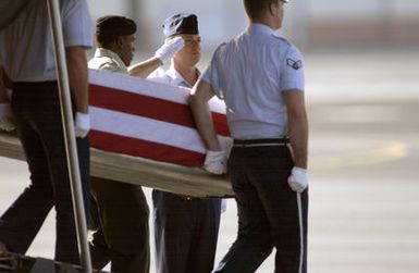 A joint military Honor Guard carries a casket draped with an American flag containing the remains of believed to be U.S. military member found in the Papua New Guinea, Laos and Burma area during a repatriation ceremony at Hickam Air Force Base, Hawaii, on Dec. 17, 2004. The remains will be taken to the Joint POW/MIA Accounting Command where the forensic identification process begins. (USAF PHOTO by Jerry Banks, CIV) (Released)