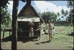 Garden produce: Kitemwalusa with yam basket, Momwaroka with coconut, Edwin Hutchins with taro plants, boards for scraping banana leaves for bundle in lower right