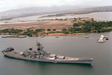 An elevated starboard bow view of the battleship USS NEW JERSEY (BB 62) approaching the USS ARIZONA Memorial