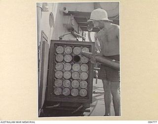 MIOS WUNDI HARBOUR, DUTCH NEW GUINEA. 1944-11-15. ABLE SEAMAN J RAPKINS STORING AMMUNITION FOR A 4 INCH GUN ABOARD HMAS STAWELL IN A READY USE LOCKER