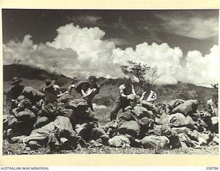 DUMPU, NEW GUINEA, 1943-10-10. A LARGE CONSIGNMENT OF MAIL IN BAGS FOR THE TROOPS OF THE 7TH AUSTRALIAN DIVISION, BEING SORTED BY MEMBERS OF THE 7TH AUSTRALIAN DIVISION POSTAL UNIT. LEFT TO RIGHT:- ..