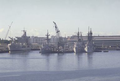 Bow views of various U.S. Navy ships moored at Bravo Piers. The ships are, from left to right, the fleet oiler USS WILLAMETTE (AO-180) the frigate USS OUELLET (FF-1077), the guided missile destroyer USS BENJAMIN STODDERT (DDG-22) and the guided missile destroyer USS HOEL (DDG-13)