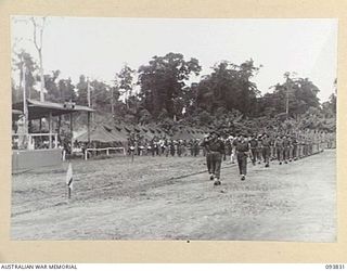 TOROKINA, BOUGAINVILLE, 1945-07-11. LIEUTENANT-GENERAL S.G. SAVIGE, GENERAL OFFICER COMMANDING 2 CORPS (1), TAKING THE SALUTE AT THE MARCH PAST DURING HIS REVIEW OF 11 INFANTRY BRIGADE AT ..
