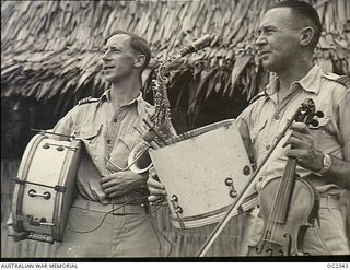 AITAPE, NORTH EAST NEW GUINEA. 1945-04-03. CO PRODUCERS OF THE ALL SERVICES P. AND A. PARADE IN NORTHERN NEW GUINEA, THE MOST POPULAR ENTERTAINMENT IN THIS AREA. CARRYING THE MUSICAL INSTRUMENTS ..