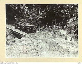 BOUGAINVILLE ISLAND. 1945-02-14. A JEEP AND TRAILER OF THE 61ST INFANTRY BATTALION CROSSING ROBERTS BRIDGE ON THE TRACK BACK TO CAMP. NOTE ROBERTS RIDGE WAS NAMED AFTER VX37706 WARRANT OFFICER II, ..