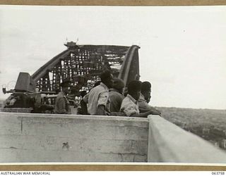SYDNEY, NSW. 1944-01-26. AUSTRALIAN AND NEW GUINEA ADMINISTRATION UNIT NATIVES VIEWING THE HARBOUR AND THE CITY FROM THE SOUTH PYLON OF THE SYDNEY HARBOUR BRIDGE DURING THEIR VISIT TO SYDNEY