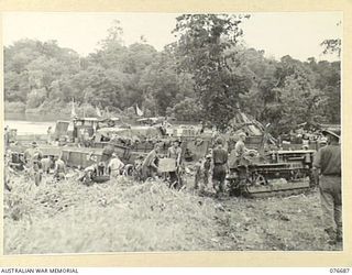 JACQUINOT BAY, NEW BRITAIN. 1944-11-05. TROOPS OF THE 6TH INFANTRY BRIGADE USING A TRACTOR AND SLED TO TRANSPORT THEIR STORES AND EQUIPMENT FROM THE BEACH TO THE UNIT CAMP