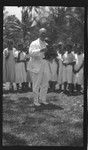 Lambert holding a camera, in front of a group of Cook Islanders