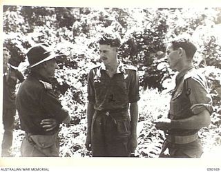 DAGUA, NEW GUINEA. 1945-03-30. MAJ-GEN J.E.S. STEVENS, GOC 6 DIVISION (1), CONGRATULATING CPL J.W. CHAPMAN, SECTION LEADER IN THE BATTALION (2), AND CAPT K.H. LOVETT, OC D COMPANY, 2/2 INFANTRY ..