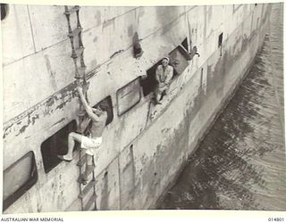 1943-05-07. NEW GUINEA. MILNE BAY. AN ALLIED VESSEL WAS HIT DURING THE 1943-04-14, JAPANESE RAID ON MILNE BAY. PICTURE SHOWS A HOLE IN THE SIDE OF THE VESSEL. (NEGATIVE BY N. BROWN)