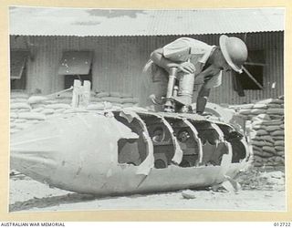 A PIECE OF JAPANESE FLYING EQUIPMENT KNOWN AS THE "BELLY TANK". THIS TANK IS USED ON THE ZERO FIGHTERS. IT IS MADE OF PLY WOOD AND HOLDS ABOUT 70 GALLONS OF PETROL. THE MOUNTING ON TOP OF THE TANK ..