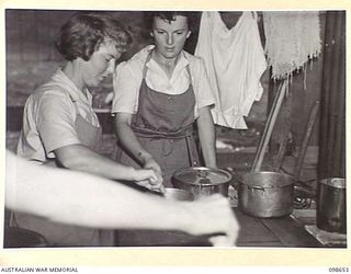 LAE, NEW GUINEA. 1945-11-08. LANCE CORPORAL E. HAMBERG, AUSTRALIAN WOMEN'S ARMY SERVICE INSTRUCTOR (2) AND SERGEANT B.L. WARD (1) MAKING WHITE SAUCE DURING THE COOKERY AND HOME CRAFT COURSE HELD AT ..