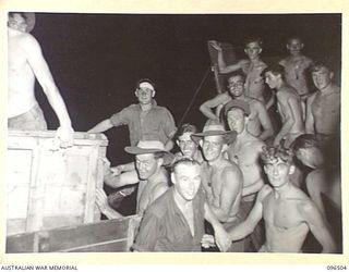 MALAGUNA MISSION, RABAUL, NEW BRITAIN, 1945-09-10. TROOPS OF 29/46 INFANTRY BATTALION, WORKED THROUGH THE NIGHT UNLOADING STORES AND EQUIPMENT TRANSPORTED TO THE BEACH-HEAD BY BARGES OPERATING TO ..