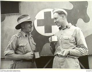 1943-07-16. NEW GUINEA. SOMEWHERE IN NEW GUINEA CAPT. CLARRIE MARTIN, ATTORNEY GENERAL FOR N.S.W. AND CAPT. DAVID GILL OF WASHINGTON, WHO IN CIVILIAN LIFE WAS A LAWYER, HAVE A CUP OF TEA AND ..