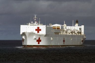 A port bow view of the US Navy (USN) Military Sealift Command (MSC), Hospital Ship, USNS MERCY (T-AH 19), underway transiting the harbor at Apra Harbor, Naval Station Guam, after arriving for a one-day stop to give the crew a break and pick up Sailors assigned to Naval Mobile Construction Battalion 40 (NMCB-40). The USNS MERCY is currently conducting a scheduled five-month deployment to deliver aid and humanitarian assistance to the Pacific Islands and Southeast Asia