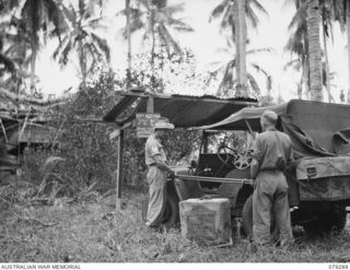 KALAI PLANTATION, HENRY REID BAY, NEW BRITAIN. 1945-02-17. NX173054 SERGEANT R.E. GEORGE (1) AND NX55910 SGT H. WINSTON (2) 82ND MOBILE CINEMA, UNLOADING THEIR PROJECTION EQUIPMENT IN PREPARATION ..