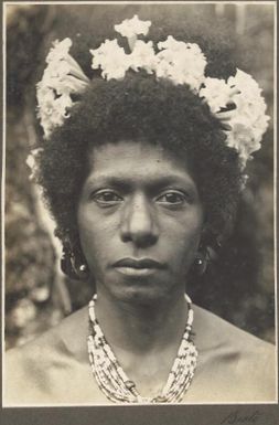 Bioto [close up of woman's face with flowers in her hair and a bead necklace] Frank Hurley