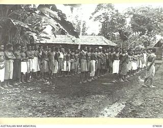 LAE, NEW GUINEA. 1944-07-22. VILLAGE BOYS WATCHING THE PARADE FOR THE GENERAL OFFICER COMMANDING, AUSTRALIAN NEW GUINEA ADMINISTRATIVE UNIT, FOR THE CEREMONY OF PRESENTING A MEDAL TO GARTER, A ..