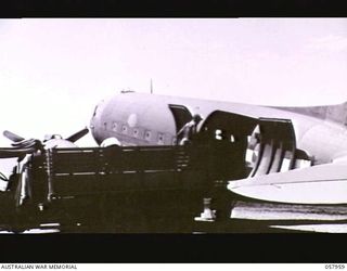 LAE, NEW GUINEA. 1943-10-11. UNLOADING A DOUGLAS TRANSPORT AIRCRAFT ON THE AIRSTRIP. A TRUCK IS BACKED UP TO A SIDE DOOR