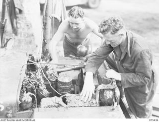 MILILAT, NEW GUINEA. 1944-08-22. NX128788 LIEUTENANT A.H. PEDEN, HEADQUARTERS, 7TH INFANTRY BRIGADE (1) ASSISTING TO WATERPROOF AN AUSTRALIAN ARMY JEEP BEFORE THE TRIALS OF THE NEW WATERPROOFING ..