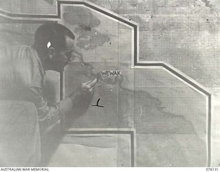 LAE, NEW GUINEA. 1944-09-12. VX81110 LIEUTENANT H.J. FORD AT WORK IN THE BATTLE ROOM, HEADQUARTERS NEW GUINEA FORCE