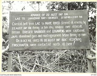 FINSCHHAFEN AREA, NEW GUINEA. 1944-03-21. ONE OF MANY BATTLE SIGNS IN THE FINSCHHAFEN AREA, THIS SIGN RECORDS THE 65 MILE ADVANCE OF THE 22ND INFANTRY BATTALION FROM LAE TO LANGEMAK BAY, AND ..