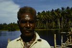 Sepik man (foreman in charge of bridge construction), village coconut grove in background, near Aitape, Oct 1961