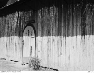 TAMIGUDU, NEW GUINEA, 1943-10-21. FRONT OF THE MISSION CHURCH SHOWING JAPANESE BULLET HOLES IN THE WALLS