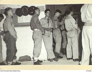 PORT MORESBY, PAPUA, 1944-02-20. AMERICAN AND AUSTRALIAN SERVICEMEN AT WORSHIP IN AN OVERFLOWING CONGREGATION AT AN ENTRANCE TO THE ROMAN CATHOLIC CHURCH