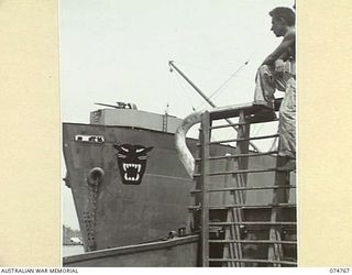 MADANG, NEW GUINEA. 1944. THE COURIER BARGE OF THE 593RD UNITED STATES BARGE COMPANY PASSING AN AMERICAN "LIBERTY" SHIP AS SHE LEAVES THE HARBOUR ON HER WAY TO ALEXISHAFEN