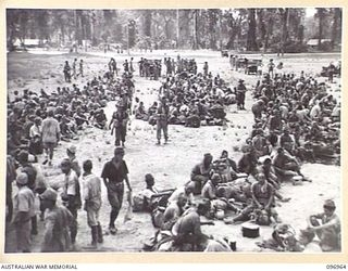 TOROKINA, BOUGAINVILLE. 1945-09-23. A GENERAL VIEW OF JAPANESE NAVAL TROOPS WHO ARE ON A 10-MILE MARCH FROM THE BUKA AREA, ESCORTED BY TROOPS OF 27 INFANTRY BATTALION, HAVING A WELCOME REST AT THE ..