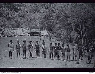 PAPUA. 1942-09. NATIVE CARRIERS LINED UP FOR INSPECTION IN UBERI VILLAGE PRIOR TO CARRYING SUPPLIES FORWARD TO OUR TROOPS IN THE IORIBAIWA AREA