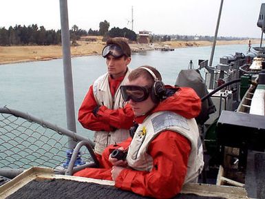 Storekeeper SEAMAN John P. Lerma (right) and Aviation Maintenance Administrationman Craig S. Mocello stand the low-visibility watch aboard the amphibious assault ship USS GUAM (LPH 9) as it transits the Suez Canal en route to the Persian Gulf. Guam deployed to the Gulf as part of an increased military presence in response to a U.S. Central Command request for additional forces in support of operation Southern Watch