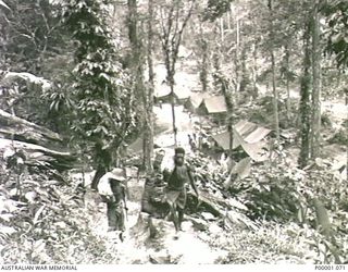 THE SOLOMON ISLANDS, 1945-03-27. NATIVE CARRIERS SETTING OUT FROM AN ALLIED CAMP ON THE NUMA NUMA TRAIL ACROSS BOUGAINVILLE ISLAND. (RNZAF OFFICIAL PHOTOGRAPH.)