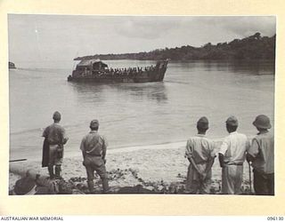 MUSCHU ISLAND, NEW GUINEA. 1945-09-11. JAPANESE WATCH FROM THE SHORE THE BARGES LOADED WITH NATIVES, THAT HAD PREVIOUSLY BEEN UNDER THEIR RULE. THEY WILL BE TAKEN TO THE NEW GUINEA MAINLAND WHERE ..