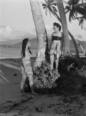 [Two young Pacific Island women standing on the beach]