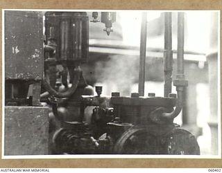 17 MILE, LALOKI RIVER, NEW GUINEA. 1943-11-22. WATER FILTER PUMP AT THE CORDIAL FACTORY ESTABLISHED AND OPERATED BY THE AUSTRALIAN DEFENCE CANTEEN SERVICES ATTACHED TO HEADQUARTERS, NEW GUINEA ..