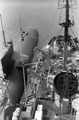 A view of the nuclear-powered attack submarine USS INDIANAPOLIS (SSN-697) and the salvage ship USS CONSERVER (ARS-39) moored abreast, as seen from the crows nest of the CONSERVER. The ships are in port to provide assistance after hurricane Iwa passed through the area