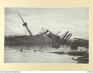 MILNE BAY, NEW GUINEA, 1944-02-09. THE M.V. ANSHUN WHICH WAS SUNK BY SHELLFIRE FROM A JAPANESE CRUISER ON 1942-09-06, IN THE PROCESS OF BEING REFLOATED BY THE COMMONWEALTH SALVAGE BOARD