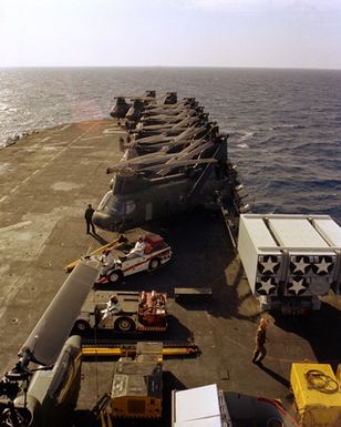 CH-46 Sea Knight helicopters, damage control vehicles and cargo line the flight deck of the amphibious assault ship USS GUAM (LPH-9), during flight operations off the coast of Beirut. The ship is providing support to U.S. Marines deployed in Lebanon as part of a multi-national peacekeeping force following confrontation between Israeli forces and the Palestine Liberation Organization