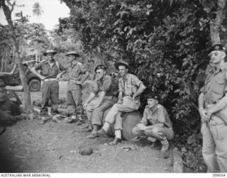 RABAUL, NEW BRITAIN. 1945-11-20. LIEUTENANT-COLONEL T. MILLS, COMMANDING OFFICER 2/4 ARMOURED REGIMENT AND OFFICERS WATCHING A TYPE 2 KA-MI AMPHIBIOUS JAPANESE TANK UNDERGOING TRIALS AT TALILI BAY