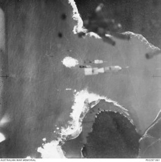 Kalai Plantation, Wide Bay, New Britain, 1944-11-06. Aerial view, taken from aft the bomb bay of a Bristol Beaufort bomber of No. 6 Squadron RAAF, showing 250-pound bombs it has just released ..