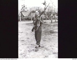 RABAUL, NEW BRITAIN, 1945-12-06. A RIFLEMAN HOLDING HIS RIFLE WITH FIXED BAYONET DURING A DEMONSTRATION OF VARIOUS INFANTRY WEAPONS. NOTE THE GRENADE ATTACHED TO HIS BELT BELOW HIS LEFT ELBOW