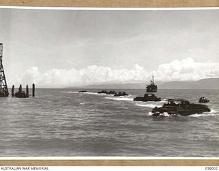LAE, NEW GUINEA. 1943-10-12. A STRING OF AMPHIBIOUS TRUCKS (DUKWS) COMING IN TO LAND AT THE DOCKS